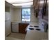 Well-lit kitchen with white appliances, a window above the sink, and wooden cabinetry at 453 S Kittredge St # D, Aurora, CO 80017