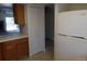 Functional kitchen setup with light countertops, wooden cabinets, and a full-size refrigerator at 453 S Kittredge St # D, Aurora, CO 80017