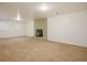 Bright basement featuring neutral carpet, a brick fireplace, and natural light from a large window at 3273 S Florence Ct, Denver, CO 80231