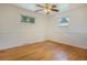 Clean bedroom with hardwood floors, two windows, and a ceiling fan, offering a bright and airy feel at 3273 S Florence Ct, Denver, CO 80231