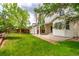 Spacious backyard featuring a lush lawn, patio, storage shed, and wood fence at 12825 Forest Way, Thornton, CO 80241