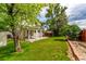 Well-maintained backyard featuring a covered patio, lawn, and garden bed at 12825 Forest Way, Thornton, CO 80241