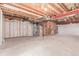 Unfinished basement featuring exposed wood ceilings, bare concrete floors, and a framed stairwell at 12825 Forest Way, Thornton, CO 80241