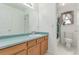 Bathroom featuring wood cabinets, an elongated mirror, and a shower and tub combo at 12825 Forest Way, Thornton, CO 80241