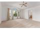 Bright bedroom featuring a ceiling fan, plush carpet, and large windows providing natural light at 12825 Forest Way, Thornton, CO 80241