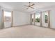 Bright bedroom featuring a ceiling fan, plush carpet, and large windows providing natural light at 12825 Forest Way, Thornton, CO 80241