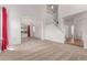 Open-concept living area with neutral carpet, leading to a staircase and dining area at 12825 Forest Way, Thornton, CO 80241