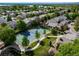 Aerial view showcases the neighborhood's tennis court, mature trees, and surrounding residences with mountain views at 4825 S Ammons St # 102, Littleton, CO 80123