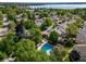 Aerial view of a neighborhood featuring a swimming pool, lush trees, and well-maintained residential properties near a lake at 4825 S Ammons St # 102, Littleton, CO 80123