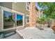 Back patio featuring sliding glass door and space for outdoor dining, with views of lush greenery and privacy fence at 4825 S Ammons St # 102, Littleton, CO 80123