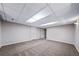 Spacious basement featuring neutral walls, plush carpet, and paneled ceiling, providing a flexible living area at 4825 S Ammons St # 102, Littleton, CO 80123