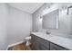 Stylish powder bathroom with a modern vanity, light fixtures, and a decorative mirror at 4825 S Ammons St # 102, Littleton, CO 80123