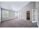 Bright bedroom featuring neutral walls, carpet and vaulted ceiling with french doors to additional room at 4825 S Ammons St # 102, Littleton, CO 80123