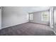 Spacious primary bedroom with neutral carpet and ample natural light from two windows at 4825 S Ammons St # 102, Littleton, CO 80123