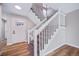 Entryway featuring a staircase with white railing, carpeted steps, laminate flooring, and a paneled front door at 4825 S Ammons St # 102, Littleton, CO 80123