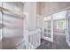 Upstairs hallway featuring natural light, stylish chandelier, and an open floorplan to bedrooms at 4825 S Ammons St # 102, Littleton, CO 80123