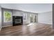 Living room featuring hardwood floors, black tiled fireplace, large windows, and a sliding glass door at 4825 S Ammons St # 102, Littleton, CO 80123
