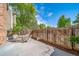 Private outdoor patio area with a dining table and chairs, surrounded by a wooden fence and lush greenery at 4825 S Ammons St # 102, Littleton, CO 80123