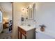 Bright bathroom with a white vanity and decorative accents. A glimpse into the bedroom is also visible at 11964 W 71St Pl, Arvada, CO 80004