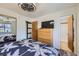 Cozy bedroom with a tropical-themed bedspread, a wooden dresser, a closet, and an ensuite bathroom at 11964 W 71St Pl, Arvada, CO 80004