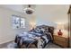 Bright bedroom featuring a tropical-themed comforter set, a wicker headboard, and a modern ceiling fan at 11964 W 71St Pl, Arvada, CO 80004