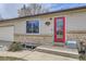 Close-up of front entry featuring a red door, brick accents, and address plaque at 11964 W 71St Pl, Arvada, CO 80004