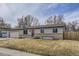 Charming ranch-style home with tan siding, brick base, and well-maintained front yard at 11964 W 71St Pl, Arvada, CO 80004