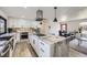 Modern kitchen with marble island, gas cooktop, and stainless steel range hood at 11964 W 71St Pl, Arvada, CO 80004