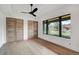 Bright bedroom with hardwood floors, modern fan, large windows showcasing the outdoor landscape, and wooden closet doors at 294 Gold Run Rd, Breckenridge, CO 80424
