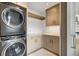 Well-organized laundry room with stacked washer/dryer, sink, ample cabinetry, and hanging space at 294 Gold Run Rd, Breckenridge, CO 80424