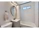 Well-lit bathroom with an oval mirror, stylish vanity, and tiled shower with curtain at 2625 S Linley Ct, Denver, CO 80219