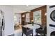 Cozy dining area with exposed brick, a white table, and living room view at 2625 S Linley Ct, Denver, CO 80219