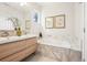 Bright bathroom featuring dual sinks, modern vanity, a soaking tub, and elegant marble accents at 4603 W 33Rd Ave, Denver, CO 80212