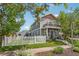 Charming two-story home with a balcony, gray siding, a white picket fence and well maintained landscaping at 4603 W 33Rd Ave, Denver, CO 80212