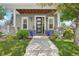 Inviting front porch with stone pillars, a modern front door, stylish planters, and a manicured lawn at 4603 W 33Rd Ave, Denver, CO 80212