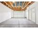 Spacious garage with high ceilings, exposed beams, concrete floors, and a door leading to the outside at 4603 W 33Rd Ave, Denver, CO 80212