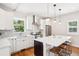 Modern kitchen features white cabinets, stainless steel appliances, a large island with seating, and hardwood floors at 4603 W 33Rd Ave, Denver, CO 80212
