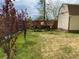 Green backyard with mature trees, and a vintage wagon providing a unique landscape feature at 4825 Estes St, Arvada, CO 80002