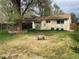 Manicured backyard with a large tree, and a charming vintage wagon, perfect for outdoor enjoyment at 4825 Estes St, Arvada, CO 80002