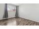 Bright bedroom featuring wood floors, neutral walls, and a window with light-filtering blinds at 4825 Estes St, Arvada, CO 80002