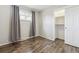 Bedroom with wood-look floors, grey curtains, and a closet at 4825 Estes St, Arvada, CO 80002