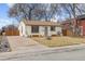 Front view of a Ranch home with a driveway and landscaping at 4825 Estes St, Arvada, CO 80002