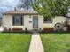 Charming single-story home featuring a well-manicured lawn and inviting curb appeal with flower boxes and a decorative wagon wheel at 4825 Estes St, Arvada, CO 80002