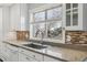 Bright kitchen features white cabinets, stainless steel sink, and tile backsplash at 4825 Estes St, Arvada, CO 80002