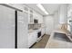 Well-lit kitchen boasting white cabinets, tiled backsplash, and modern appliances for a clean and functional space at 4825 Estes St, Arvada, CO 80002