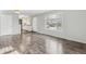 Open-concept area showing laminate floors, a large window, and the entry to the kitchen at 4825 Estes St, Arvada, CO 80002