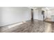 Open-concept living area with attractive laminate flooring and a glimpse of the kitchen and entryway at 4825 Estes St, Arvada, CO 80002