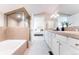 Bathroom showcasing a double sink vanity, tub, and shower at 1699 N Downing St # 409, Denver, CO 80218