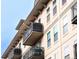 Exterior view of a tan building featuring balconies with metal railings and multiple windows under a clear blue sky at 1699 N Downing St # 409, Denver, CO 80218