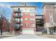 Building exterior featuring a brick facade, multiple balconies, a secure garage and private entrance at 1699 N Downing St # 409, Denver, CO 80218